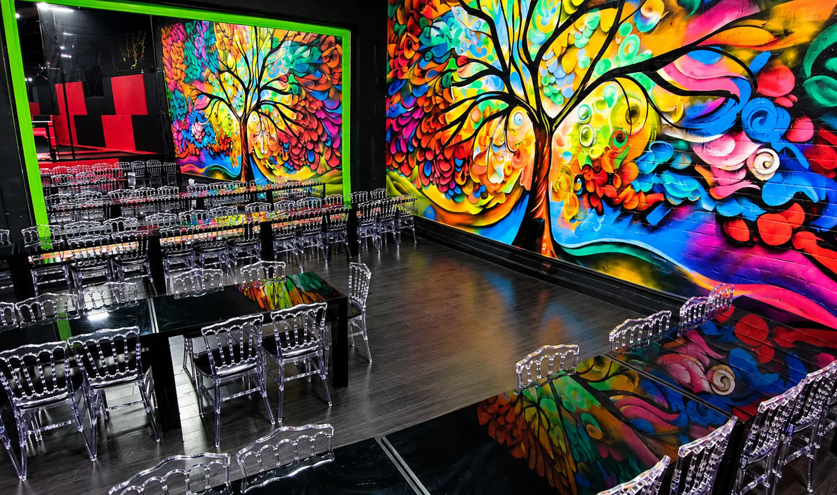 ADULT PACKAGE TUJUNGA party venue with clear chairs tables glossy floors and colorful tree murals for private celebrations and events