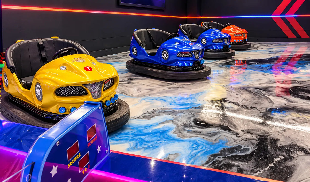 RIDE AND FUN PACKAGE TUJUNGA featuring colorful bumper cars on a vibrant indoor track with illuminated walls and a polished family entertainment venue floor